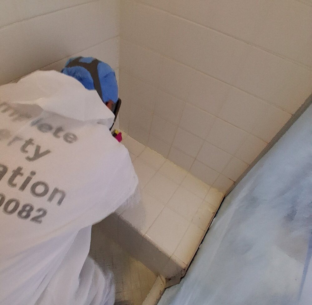 CPR technician performing detailed cleaning in protective equipment